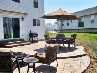 Ashlar stamped concrete job by T and H Foundations Ashlar stamped concrete patio with table, chairs, and firepit