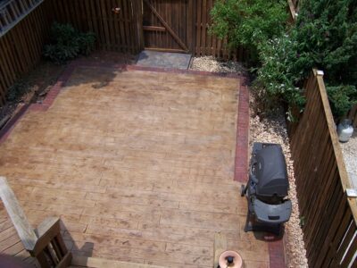 Wood Plank (Boradwalk BW170) stamped concrete job by Interscope Contractors fenced-in wood plank stamped patio with grill and seating
